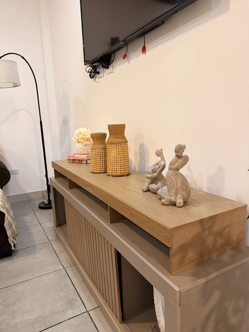 Consola de madera con jarrones de fibras naturales y esculturas decorativas